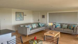 a living room with two couches and a table at Island View 1 in Coffin Bay