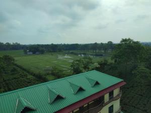 a building with a green roof and a golf course at Maa Greenary View - A Holiday Resort in Alīpur Duār