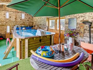 een patio met een hot tub en een tafel met een parasol bij 1 Bed in Abergavenny BN113 in Pont Newydd