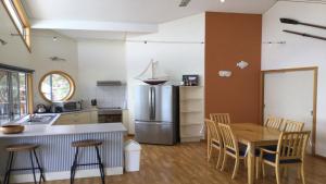 a kitchen with a table and a stainless steel refrigerator at Rest A Shore Coffin Bay in Coffin Bay