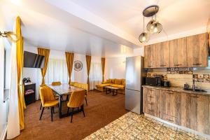 a kitchen and a dining room with a table and chairs at Casa Sinca in Timisul de Jos