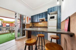 a kitchen with a counter and stools in a room at Casa Doña Margarita in Tuineje