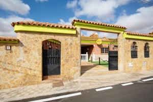 un bâtiment en briques avec des portes noires dans une rue dans l'établissement Casa Doña Margarita, à Tuineje