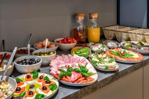 a buffet with many plates of food on a counter at Cotton House in Łódź