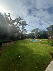 a large yard with a swimming pool and trees at Palm Cottage in Trafalgar