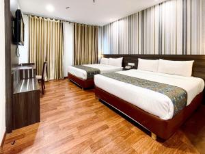 Habitación de hotel con 2 camas y TV de pantalla plana. en My Hotel @ Bukit Bintang, en Kuala Lumpur