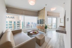 een woonkamer met een bank en een groot raam bij Boutique Living - Burj Views - Renovated in Dubai