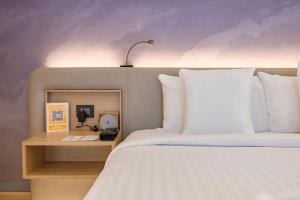 a bedroom with a bed and a desk with a phone at Novotel Ahmedabad in Ahmedabad