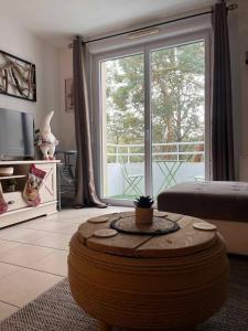 een woonkamer met een groot raam en een salontafel bij L'Eucalyptus in Marans