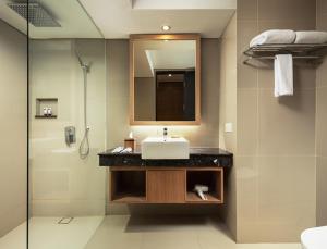 W łazience znajduje się umywalka i lustro. w obiekcie FOX Hotel Jimbaran Beach w mieście Jimbaran