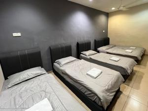 three beds in a room with a wall at Pekan Budget Hotel in Pekan
