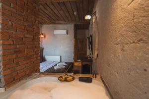 a bathroom with a bath tub in a brick wall at Alin Stone House in Uchisar