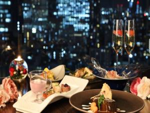a table with plates of food and glasses of wine at Shinjuku Prince Hotel in Tokyo