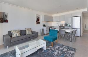 ein Wohnzimmer mit einem Sofa und einem Tisch in der Unterkunft The Cosmo Luxury Suites by Totalstay in Kapstadt