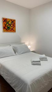 Una cama blanca con dos toallas encima. en Casa Valentina 1, en Perugia