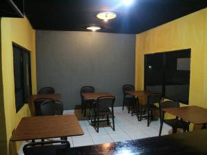 ein Zimmer mit Tischen und Stühlen in einem Restaurant in der Unterkunft Tange Guest House in Ruteng
