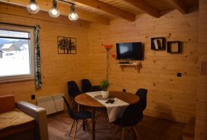 ein Esszimmer mit einem Tisch und Stühlen sowie einem TV in der Unterkunft Domki Nad Potokiem in Tyrawa Wołoska