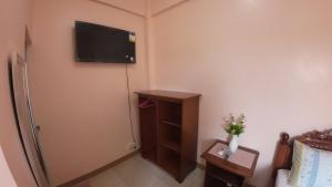 a room with a refrigerator and a tv on the wall at Queenslander Hotel and Restaurant in Alaminos