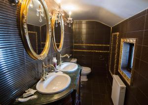 a bathroom with two sinks and mirrors and a toilet at Casa Cu Farfurii in Sinaia