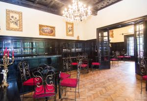 a dining room with red chairs and a chandelier at Casa Cu Farfurii in Sinaia