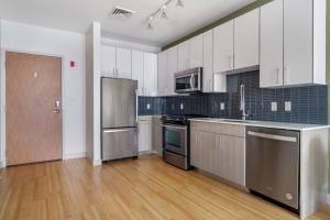 a large kitchen with stainless steel appliances and wooden floors at South Boston 1br w gym nr red line shops BOS-984 in Boston