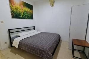 a bed in a bedroom with a picture on the wall at The Forest Villa in Bogor