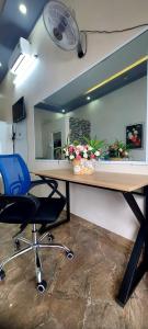 a desk with a blue chair and a mirror at SKY HOMESTAY in Buon Ma Thuot