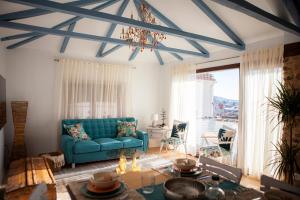 a living room with a blue couch and a chandelier at La Ermita de Moral - Casas boutique in Moral de Calatrava