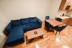 a living room with a blue couch and a table at Apartman Ivkovic Zlatibor in Zlatibor +7 photos