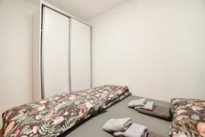 a room with two beds and towels on the floor at Apartman Ivkovic Zlatibor in Zlatibor