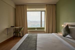 罗纳瓦拉Ikshana Resort and Spa, Khandala的一间有床和窗户的酒店房间