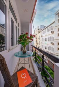 a table on a balcony with a vase of flowers at Home De Art -303 in Ho Chi Minh City