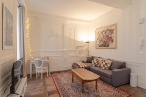 a living room with a couch and a table at La Blanche Hermine - Appartement centre de Rennes in Rennes