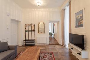 a living room with a couch and a tv at La Blanche Hermine - Appartement centre de Rennes in Rennes +5 photos