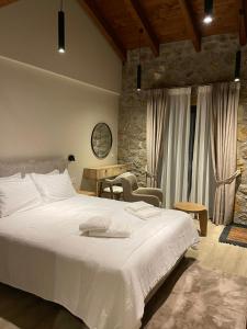 a bedroom with a large white bed and a table at Miltilon in Synikia Mesi Trikalon