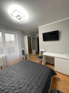 sypialnia z łóżkiem i telewizorem na ścianie w obiekcie Золотий Лев w mieście Zvenyhorodka
