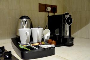 uma bandeja preta com utensílios e comodidades para preparar café em Crown Tower Hotel em Al Jubail