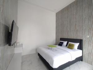 Una televisión o centro de entretenimiento en Urbanview Hotel Nimara Ngawi by RedDoorz