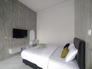 Una televisión o centro de entretenimiento en Urbanview Hotel Nimara Ngawi by RedDoorz