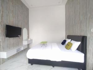 Una cama o camas en una habitación de Urbanview Hotel Nimara Ngawi by RedDoorz