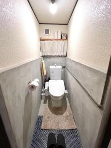 uma pequena casa de banho com um WC e um rolo de papel higiénico em おとまち 甘藍 Otomachi Kanran em Kure