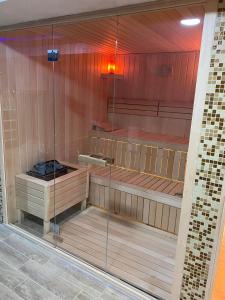a sauna with a wooden floor and glass walls at Apartman Ivkovic Zlatibor in Zlatibor