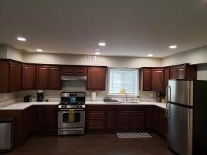 a kitchen with wooden cabinets and a stainless steel refrigerator at Ridgeland Retreat/ Street level Apt easy access in Berwyn
