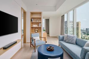 a living room with a couch and a tv at Doubletree By Hilton Shenzhen Airport Residences in Shenzhen