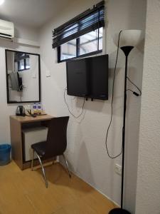 a room with a desk and a television on a wall at Maple Boutique Hotel Kota Bharu in Kota Bharu