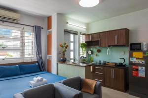 a living room with a blue couch and a kitchen at Home De Art -303 in Ho Chi Minh City