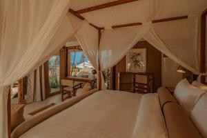 邦濤海灘的住宿－The Lazy Coconut Glamping，一间卧室设有一张大床和一个窗户。