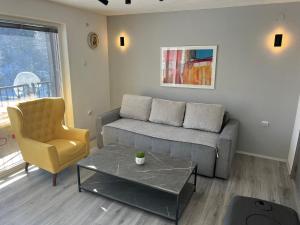 a living room with a couch and a chair at Mavrovo Square " Villas & Apartment " in Mavrovo