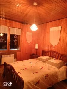 a bedroom with a large bed with red leaves on it at Chalet de montagne Pierre et Gaby non-fumeur hôte non professionnel in Saint-Jean-dʼAulps