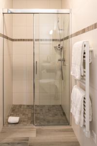 a shower with a glass door in a bathroom at Motel-Résidence Ô Pied à Terre in Montilliez